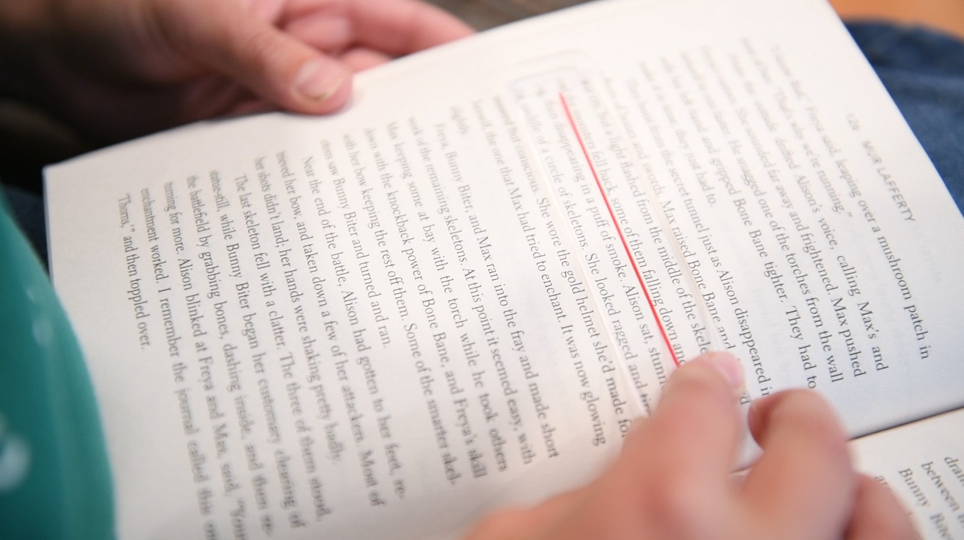 Person using a Reading Overlay - Clear Underliner on a book page for easier reading.